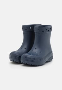 Bottes de pluie en caoutchouc marine à coupe basse, à bout rond, avec semelle texturée, trous de ventilation et finition lisse. Conçues pour être résistantes à l'eau.