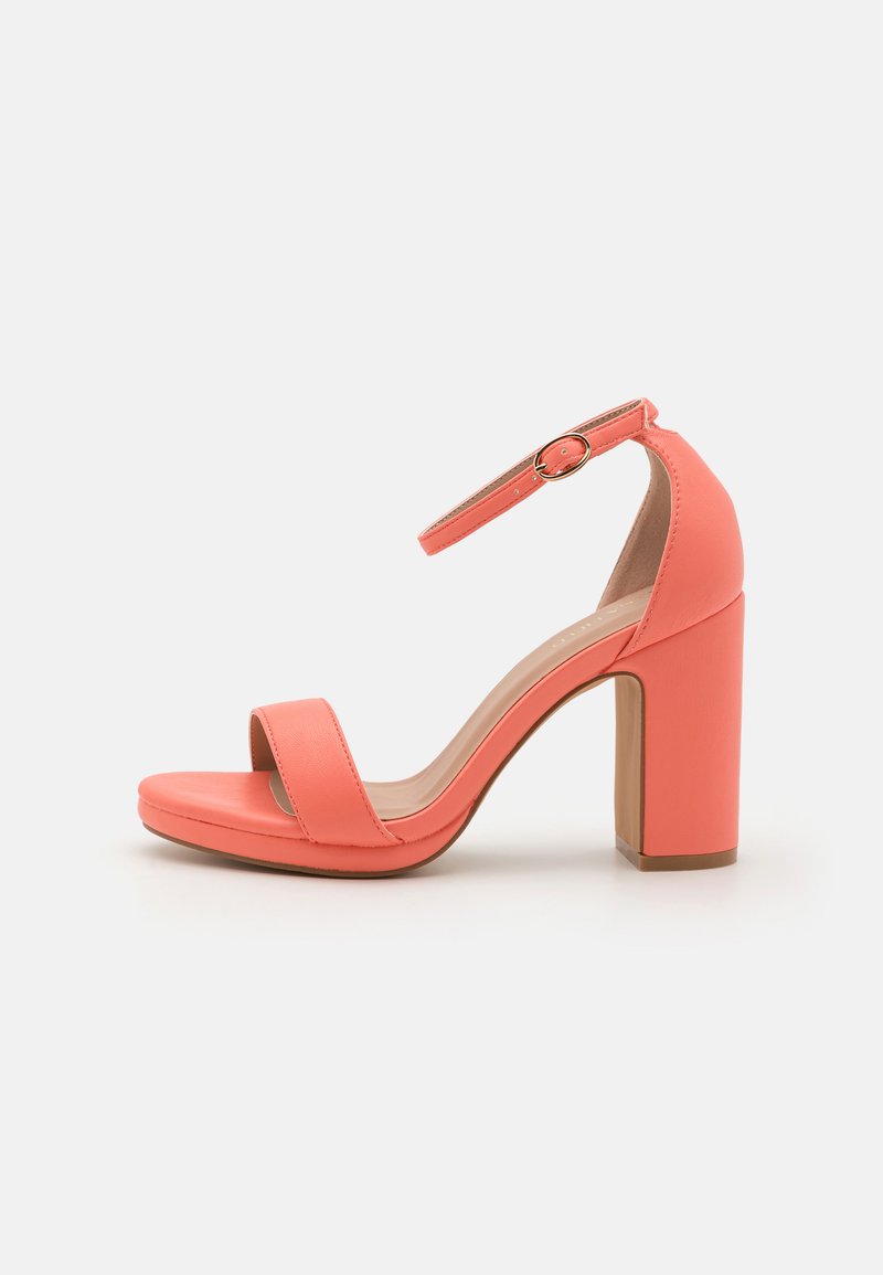 Coral high-heeled sandal with a thick block heel, open toe, and ankle strap featuring a round gold buckle. Smooth synthetic material.