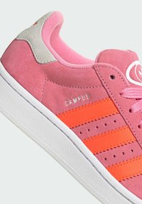 Sapatilha de camurça rosa com três riscas laranja, sola texturada branca, marcação prateada "CAMPUS" e atacadores rosa combinando.