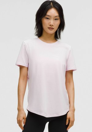 Lys rosa T-shirt med korte ærmer og rund halsudskæring, lavet af blødt stof. Har en buet søm og en afslappet pasform for komfort.