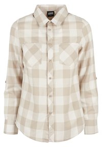 Chemise à manches longues avec boutons, grand motif à carreaux beige et blanc, deux poches poitrine et col pointu.