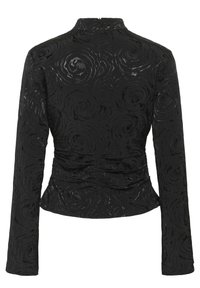 Veste noire à manches longues avec un motif de roses texturé, coupe ajustée, col haut et fermeture éclair au dos, avec un léger brillant.
