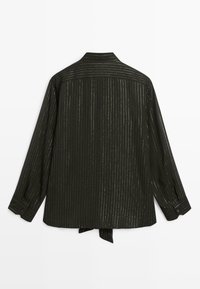 Czarna koszula z długimi rękawami, pionowe metaliczne złote paski, mankiety na guziki oraz detal z wiązaniem z tyłu. Gładka faktura, strukturalny krój.