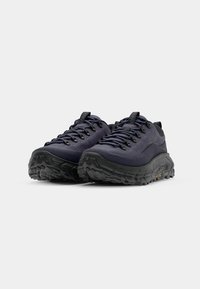 Zapatos de senderismo navy con una suela negra texturizada, que presentan cordones en contraste y un diseño minimalista, adecuados para terrenos difíciles.