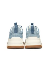 Sneakers in denim blu con una suola intermedia bianca ammortizzata e una suola esterna in gomma marrone. Presentano un'etichetta sul tallone in tessuto e dettagli testurizzati sulla tomaia.