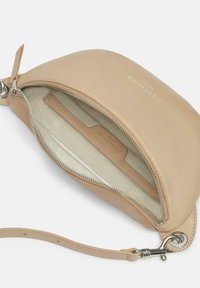 Tan leather clutch bag with a smooth texture, zip closure, and a wrist strap. Interior features a beige fabric lining and a card slot.