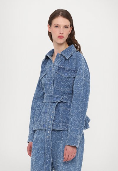Jachetă din denim de un albastru deschis, cu o finisare texturată, având talie cu curea, două buzunare pe piept și un guler clasic.