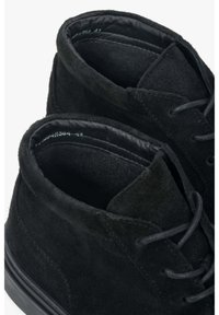 Czarne zamszowe botki za kostkę o teksturowanej powierzchni, zaokrąglonym czubku i czarnych sznurówkach. Miękka podszewka i subtelne detale w szyciu.