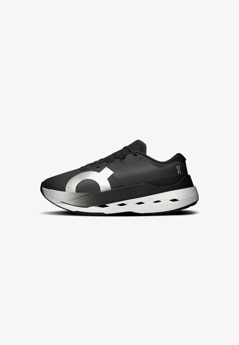 Chaussure de course noire avec grand logo blanc sur le côté, semelle blanche rembourrée avec trous d’aération, et lacets noirs.