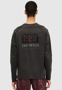 Long-sleeve shirt in dark gray cotton, featuring a graphic print in red and white on the back, and raglan sleeves for a relaxed fit.