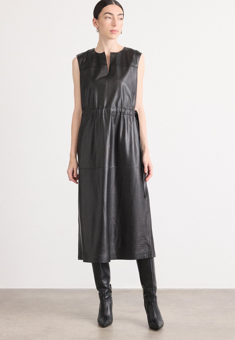 Schwarzes Leder-Midi-Kleid mit ärmellos Design, hohem Ausschnitt, tailliertem Bund und glatter Textur; präsentiert sich in einem maßgeschneiderten und minimalistischen Stil.