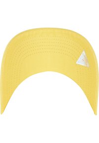 Żółta czapka baseballowa z usztywnionym daszkiem, wykonana z teksturowanej tkaniny. Na boku znajduje się trójkątny naszywka z logo. Stylizowana na codzienny strój.