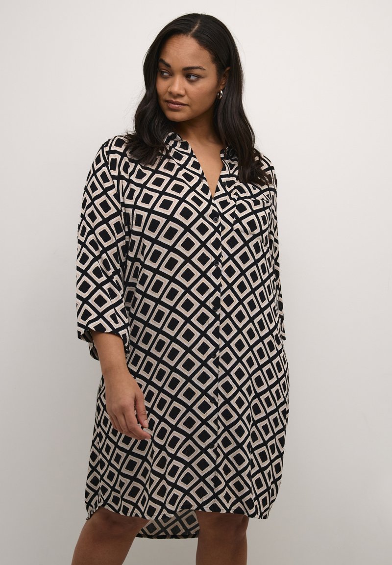 Schwarz-creamfarbenes Hemdblusenkleid mit einem Diamantmuster, featuring eine durchgehende Knopfleiste, Dreiviertelärmel und einer entspannten Passform.
