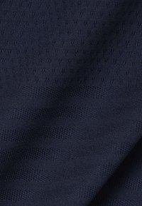 Tela azul marino con rayas texturizadas alternas y un patrón de pequeños puntos elevados, mostrando pliegues suaves y detalles de tejido fino.