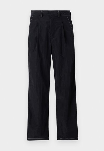 Μαύροι παντελόνια φαρδιάς γραμμής με υφή και ορατές ραφές. Διαθέτουν ζώνη μέσης με θηλιές και επίπεδο σχέδιο εμπρός.