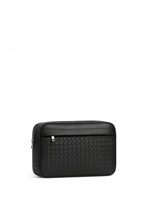 Black leather toiletry bag with woven texture, rectangular shape, and zipper closure on white background.
