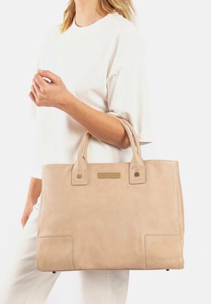Beige leren tote bag met twee handgrepen aan de bovenkant, vierkante vorm, voorzakdetail en subtiele stikselaccenten. Glad textuur en minimalistisch ontwerp.