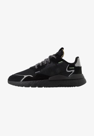 Baskets de sport noires avec semelle texturée, panneaux en mesh et en suède, accents réfléchissants, lacets à motifs et col rembourré, vues de côté.