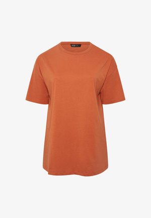 Prosty, krótki rękaw, pomarańczowo-rdzawy T-shirt z okrągłym dekoltem, o luźnym kroju, z widoczną metką marki wewnątrz kołnierza.