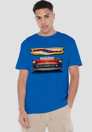 Blaues T-Shirt mit kurzen Ärmeln, das eine Grafik eines vintage roten Autos und ein Chevrolet-Logo mit gelben und blauen Akzenten zeigt. Aus Baumwollmaterial.