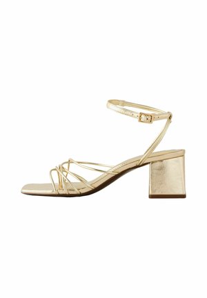 Sandałki na niskim, szerokim obcasie z złotymi paskami, regulowanym paskiem wokół kostki, odkrytymi palcami oraz kwadratowym kształtem przodu.
