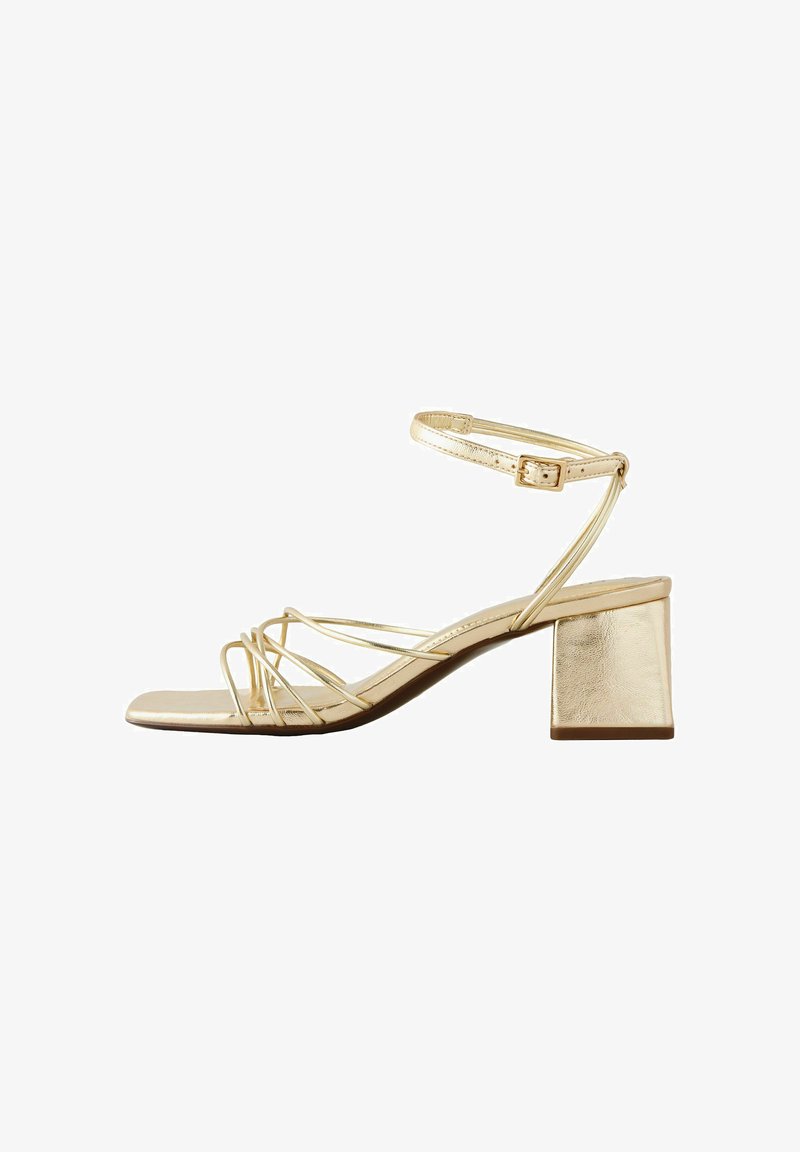 Sandale aurii cu barete, toc mic și gros, curea reglabilă la gleznă, degetele deschise și design cu vârf pătrat.