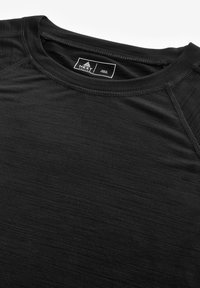 Schwarzes Kurzarmshirt mit rundem Ausschnitt. Glatte Textur, leichtes Material und Raglanärmel. Markenlabel innen am Kragen sichtbar.