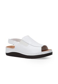 Weiße offene Sandalen mit einem Rückengurt und elastischen Seiteneinsätzen, ausgestattet mit einer kontrastierenden dunklen Sohle. Einfaches, lässiges Design für den Sommer.
