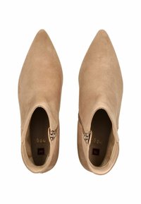 Beige suede ankle boots with a pointed toe and zip closure. Smooth texture and minimalistic design, featuring a subtle brand logo inside.