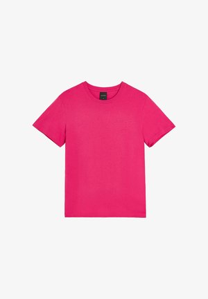 Jasnoróżowa koszulka z krótkim rękawem i okrągłym dekoltem z małym, subtelnym logo na lewej piersi, pokazana na płasko na białym tle.