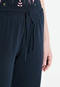 Navyblauwe joggingbroek van zacht materiaal, met een elastische tailleband en trekkoord. Gladde textuur, casual pasvorm en geen zichtbare patronen.