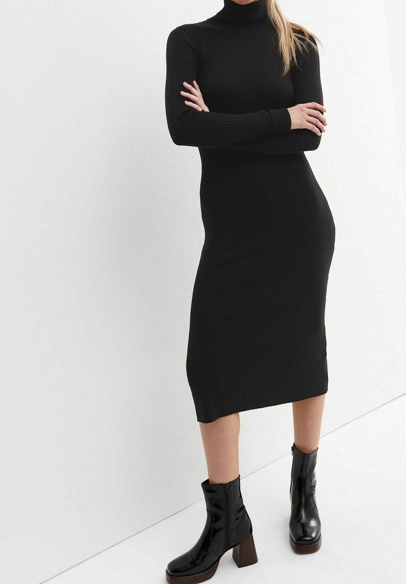 Svart ribbat polotröja klänning, långa ärmar, längd till mitten av vaden, gjort av sträckt tyg, tillsammans med svarta klackade anklar stövlar för kontrast.