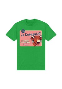 Zelené tričko s vintage grafikou smějící se krávy a textem, umístěné na růžovém pozadí, s retro designem.