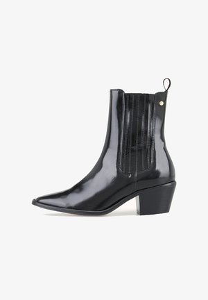 Bottine en cuir noir brillant avec bout pointu, panneaux latéraux élastiques, languette à l'arrière et talon carré.