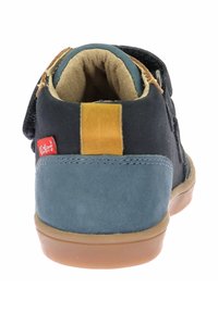 Scarpe per bambini nere e blu con parte superiore in suede e tessuto, accento beige, fascia a strappo e suola in gomma. Dettaglio del logo rosso sul lato.