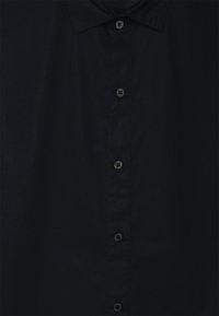Camicia abbottonata blu scuro realizzata in tessuto liscia, con un colletto classico, sei bottoni neri lungo la placket e una superficie semplice.