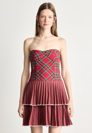 Vestido sin mangas de cuadros rojos con un cuerpo ajustado, falda de volantes en capas y encaje blanco en el dobladillo. Hecho de una mezcla de algodón.