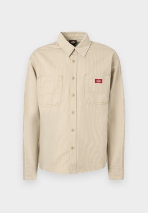 Beige- en witgestreept overhemd met lange mouwen, knoopsluiting, kraag, twee borstzakken en een rood Dickies-logo op het rechterzakje.