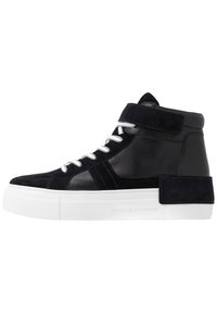 Korkeavartiset tennarit tummansinisestä nahasta ja sametista, valkoisilla nauhoilla, pehmustetulla kauluksella ja paksulla valkoisella pohjalla, jossa on teksturoidut yksityiskohdat.