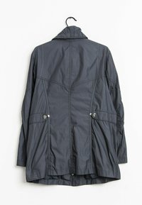 Mörkgrå, lätt jacka med krage, tryckknappar, sidofickor, plisserad baksidesdesign och textilstruktur. Upphängningsslinga ingår.