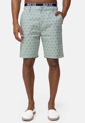 Shorts vert clair avec un motif géométrique, dotés d'une taille en marine étiquetée "INDICODE", et d'une coupe décontractée. Matière en coton texturé.