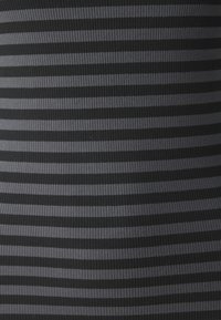 Svart och mörkgrå randig tyg med ribbad yta, som har växlande ränder i olika bredder. Slätt och elastiskt material.