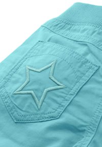 Turkusowa tkanina z teksturowanym haftem gwiazdy na tylnej kieszeni; cechą są żebrowany pas oraz gładka faktura.