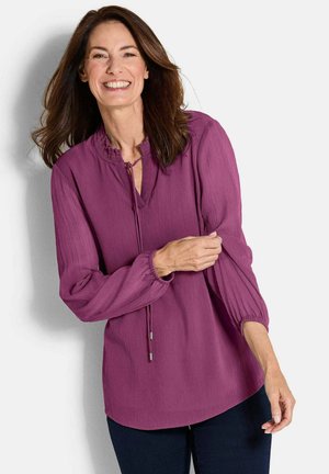 Paarse blouse met een geplooide halslijn, lange mouwen met elastische manchetten en een losse pasvorm. De stof heeft een gestructureerd, gekreukt uiterlijk.