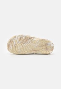 Suola di scarpa in gomma trasparente con un motivo di battistrada intricato, di colore beige chiaro e superficie texture per una migliore aderenza.