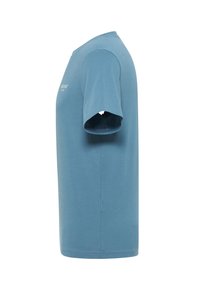 Jasnoniebieski, krótko rękawowy t-shirt z okrągłym dekoltem i metką po boku. Wykonany z miękkiego materiału o gładkiej strukturze.