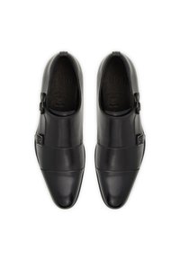 Zapatos de vestir de cuero negro con un diseño elegante, que presentan una doble correa y herrajes de hebilla, textura suave y una punta afilada.
