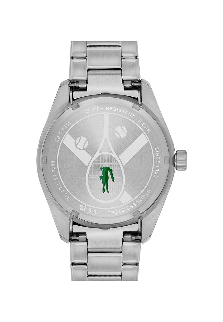 Parte trasera de un reloj de acero inoxidable con grabado de una raqueta de tenis y pelotas, logo de cocodrilo verde, resistente al agua hasta 5 bares, correa de eslabones metálicos.