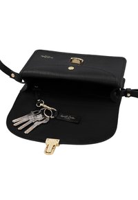 Melnas ādas rokassoma ar zelta aizdari atvērta, tajā ir piestiprināta atslēgu riņķa ar piecām sudraba atslēgām.