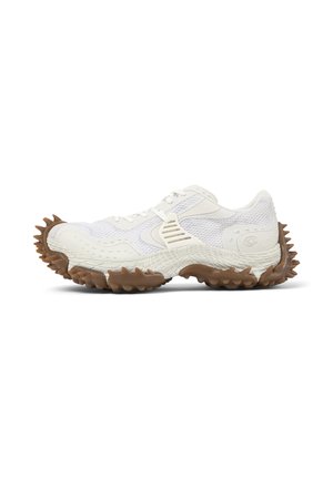 Weißer Sportschuh mit Mesh-Obermaterial und einzigartiger brauner, stacheliger Sohle und Ferse, von der Seite auf weißem Hintergrund gezeigt.